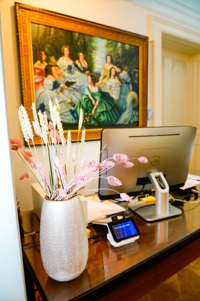 tavolo della reception con alle spalle un quadro in stile classico