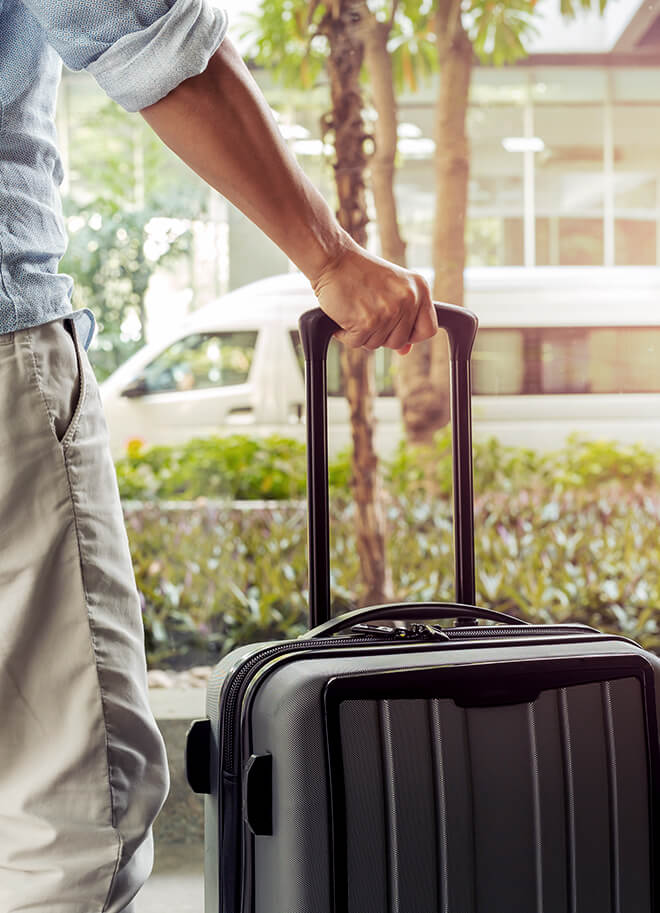 uomo con valigia che attende il servizio transfer aeroportuale